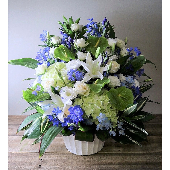 白と青の花々にユリが添えられた、移転祝いのアレンジメント