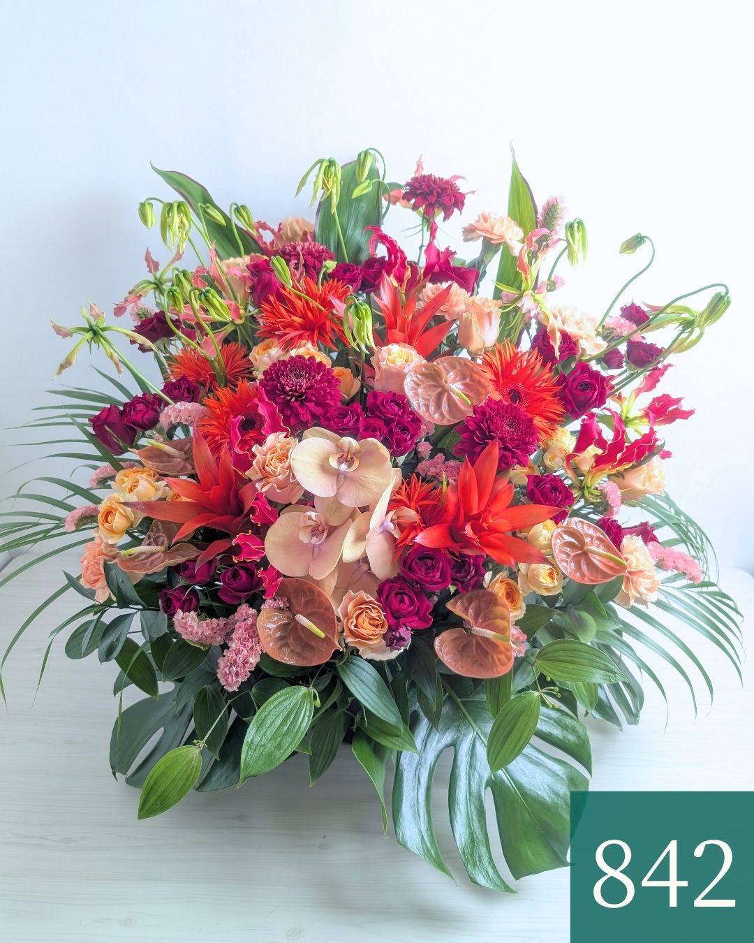 オレンジ色と赤色の花束、おしゃれなアレンジメント。会社のお祝い・記念日に喜ばれるお花のギフト