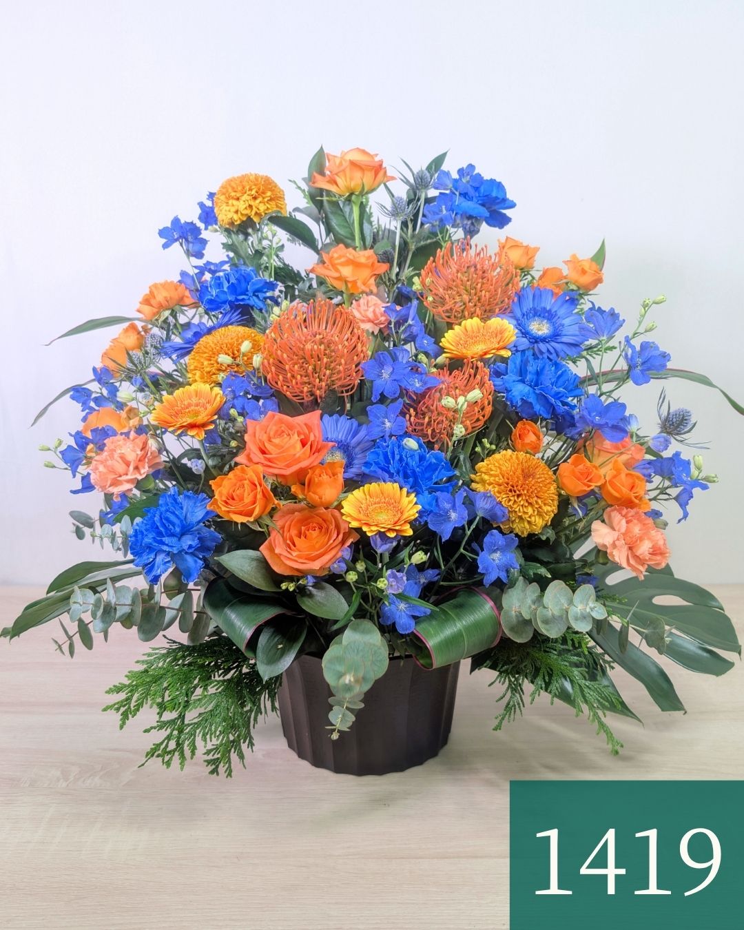 青色とオレンジ色の花束、おしゃれなアレンジメント。お祝い・記念日に喜ばれるお花のギフト