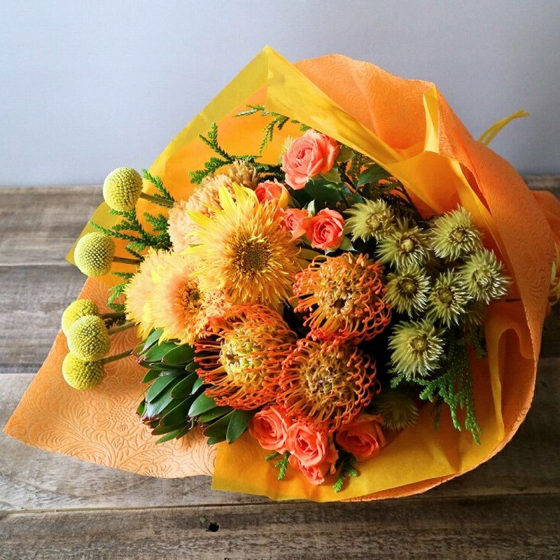 お花のプレゼント、贈り物。黄色とオレンジ色の花束・アレンジメントを贈る。フラワーギフト