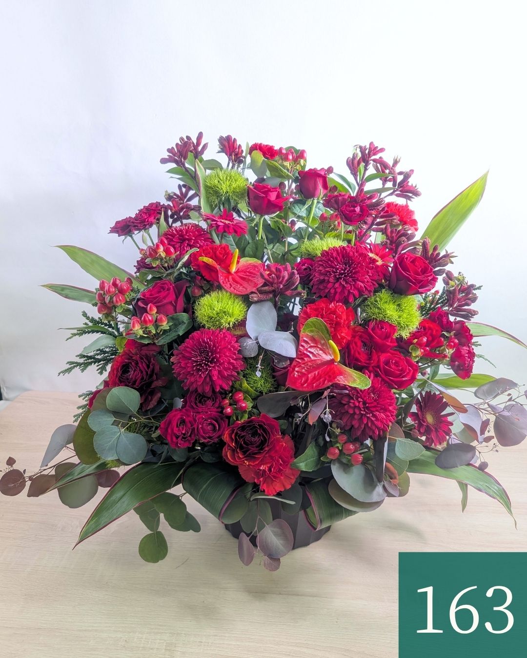 赤色の花束、アレンジメント。ビジネスのお祝いに贈るフラワーギフト。