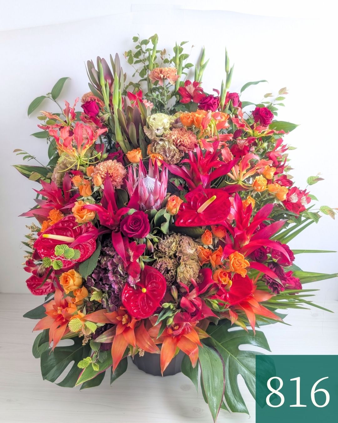 オレンジ色と赤色の花束、おしゃれなアレンジメント。会社のお祝い・記念日に喜ばれるお花のギフト